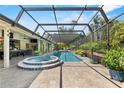 Stunning screened-in pool area featuring a spa and patio with beautiful landscaping at 7313 Crape Myrtle Way, Sarasota, FL 34241