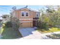 Inviting two-story home with a two-car garage, complemented by lush landscaping and a cozy front entrance at 1401 Parker Den Dr, Ruskin, FL 33570