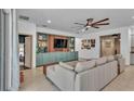 Comfortable living room with built-in shelving, a ceiling fan and a large sectional sofa at 15706 Starling Water Dr, Lithia, FL 33547
