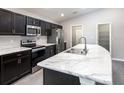 Modern kitchen boasts stainless steel appliances, marble countertops, and dark wood cabinetry at 2512 58Th E Cir, Palmetto, FL 34221