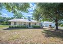 Charming single-story home with a metal roof, welcoming front porch and a manicured lawn at 4020 Mcintosh Rd, Dover, FL 33527