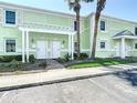 Inviting two-story condo with a light green facade, white shutters, and a decorative pergola entrance at 4778 Coquina Key Se Dr # 4778, St Petersburg, FL 33705