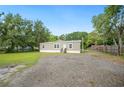 Cozy single-story home with gravel driveway and lush greenery at 6433 Mangrove Dr, Wesley Chapel, FL 33544