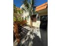 A close-up of a condo entrance featuring a fenced-in yard with gravel and tropical foliage at 135 Wild Palm Dr, Bradenton, FL 34210