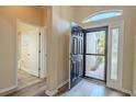 Bright foyer with wood-look flooring and a view of the front door and adjacent bathroom at 3419 Trapnell Ridge Dr, Plant City, FL 33567