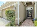 View of the home's exterior featuring the front door, landscaping, and address numbers with neutral tones at 3419 Trapnell Ridge Dr, Plant City, FL 33567