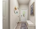 Inviting hallway with decorative tile flooring, neutral walls, and a front door with stained glass at 10642 Lake Montauk Dr, Riverview, FL 33578