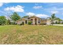 Beautiful single-story home with a three-car garage, arched entry, and lush green lawn at 11447 Adelia St, Spring Hill, FL 34608