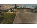 Charming single-story home at dusk featuring a spacious three-car garage and manicured front yard at 11447 Adelia St, Spring Hill, FL 34608