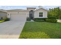 Attractive home showcasing a well-kept lawn, two-car garage, and welcoming front door at 15354 Sweet Springs Bnd, Odessa, FL 33556