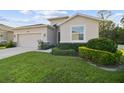 View of a home's exterior with a lush green lawn, a paved driveway, and a two-car garage at 15354 Sweet Springs Bnd, Odessa, FL 33556