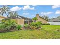 View of spacious backyard featuring screened-in patio and landscaping at 2912 Aston Ave, Plant City, FL 33566