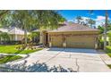 Lovely home featuring a three-car garage, beautiful stone accents, and a well-maintained lawn at 3620 Cordgrass Dr, Valrico, FL 33596