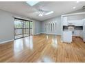 Open-concept living space with wood flooring, modern ceiling fan, and sliding door access to the balcony at 6350 92Nd N Pl # 2206, Pinellas Park, FL 33782