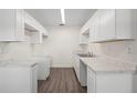 Modern kitchen boasts new white cabinets, countertops, and gray wood-look flooring at 6011 67Th N Ave, Pinellas Park, FL 33781