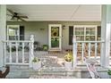 Charming front porch with white railing, decorated with plants and a patriotic wreath at 9912 Pine Leaf Ln, Dade City, FL 33525