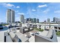A rooftop deck with seating areas and panoramic views of the city skyline under a blue sky at 101 S 12Th St # 318, Tampa, FL 33602