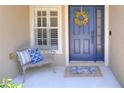 Cozy front porch with a blue door, decorative wreath, seating, and patterned rug, creating a welcoming entry at 1233 Emerald Hill Way, Valrico, FL 33594