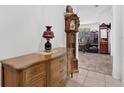 Traditional foyer area featuring a decorative cabinet, grandfather clock and neutral tile flooring at 163 Shell Falls Dr, Apollo Beach, FL 33572