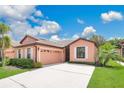 Beautiful one-story home with a lush lawn, concrete driveway and tropical landscaping at 163 Shell Falls Dr, Apollo Beach, FL 33572