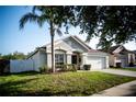 Single-story home featuring a two-car garage and a neatly manicured lawn at 11567 Misty Isle Ln, Riverview, FL 33579