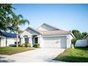Well-kept single-story home with a two-car garage and mature landscaping at 11567 Misty Isle Ln, Riverview, FL 33579