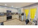 Bright kitchen featuring stainless steel appliances, granite countertops, and wood-look tile flooring at 13411 Whitby Rd, Hudson, FL 34667
