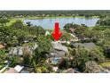 Aerial view showcasing property with pool and lake in the distance amid surrounding trees at 2872 Hammock Dr, Plant City, FL 33566