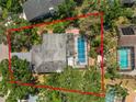 An aerial view showcasing the property's pool and backyard surrounded by lush greenery and mature trees at 2872 Hammock Dr, Plant City, FL 33566