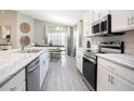 Open-concept kitchen featuring stainless steel appliances, marble countertops, and adjacent dining area at 6957 161St E Ter, Parrish, FL 34219