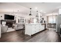 Open-concept living space with modern island, hardwood floors, and seamless flow to living and dining areas at 7608 Franklin Rd, Plant City, FL 33565