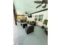 Spacious covered patio with outdoor seating, ceiling fans, and a mounted television, perfect for entertaining at 7608 Franklin Rd, Plant City, FL 33565