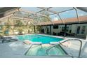 Inviting pool with a screened enclosure, hot tub, and ample seating for outdoor enjoyment at 7608 Franklin Rd, Plant City, FL 33565