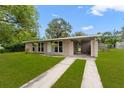 Inviting home featuring a spacious lawn and an attached carport at 1018 Briarwood Ave, Tampa, FL 33613