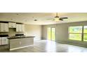 Bright living room featuring tile flooring, a ceiling fan, and sliding glass doors to the backyard at 3188 Nubbin Ridge Ln, Zephyrhills, FL 33540