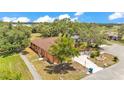 Aerial view of home featuring a neutral stucco exterior, mature trees, and a long driveway at 5370 Boxtree Ct, Dade City, FL 33523