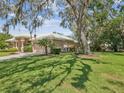 Home with manicured lawn, mature trees, and lush landscaping enhancing its curb appeal at 5903 Cachette De Riviera Ct, New Port Richey, FL 34655