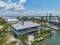 Aerial view of a waterfront home with a screened porch and boat dock on a canal at 9712 Little Gasparilla Is, Boca Grande, FL 33921