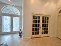 Elegant foyer featuring decorative glass doors, tile flooring, and an open entryway, creating a welcoming ambiance at 1909 Masters Way, Plant City, FL 33566