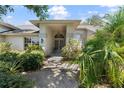 Welcoming front entrance with lush greenery, a decorative front door, and a covered porch at 1909 Masters Way, Plant City, FL 33566