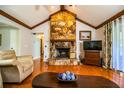 Cozy living room boasts a stone fireplace, vaulted ceilings, and warm hardwood floors at 2223 Wildwood Hollow Dr, Valrico, FL 33596