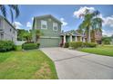 A beautiful two-story home featuring lush green lawns, mature palm trees, and a concrete driveway at 2721 Walden Woods Dr, Plant City, FL 33566