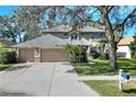Inviting two-story home boasts a three-car garage, beautiful lawn, and mature trees for added curb appeal at 3507 Autumn Glen Dr, Valrico, FL 33596