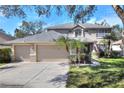 Beautiful home with a three-car garage, mature trees and an American flag in the front yard at 3507 Autumn Glen Dr, Valrico, FL 33596