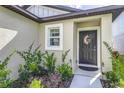 Close up of front door with a decorative wreath and well maintained landscaping at 4035 Radiant Mountain Dr, Plant City, FL 33565