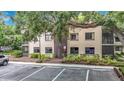 Condo building featuring ample parking and verdant shrubbery along the foundation at 11704 Raintree Village Blvd # B, Temple Terrace, FL 33617