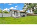A spacious backyard featuring a well-maintained lawn, white fence, and exterior home architecture at 1603 N Park Rd, Plant City, FL 33563