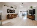 Bright and open living room with a high ceiling, with white walls, light wood floors, chandelier and lots of natural light at 2024 E Del Webb Blvd, Sun City Center, FL 33573