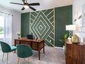 Stylish home office featuring a wood desk, green accent wall, and elegant decor at 35392 Coventry Fields Loop, Zephyrhills, FL 33541