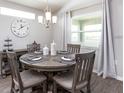 Bright cafe with a wooden table setting for four, pendant lighting, and natural light from the window at 35494 Coventry Fields Loop, Zephyrhills, FL 33541